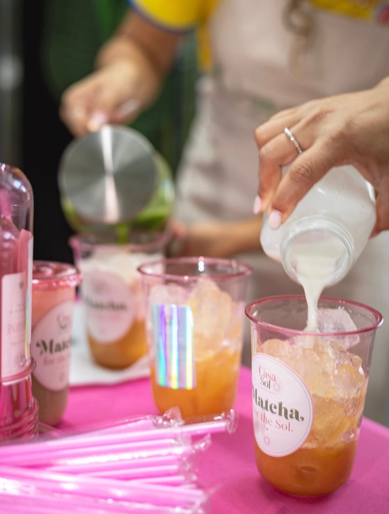 Milk being poured into matcha drinks at the Casa Sol table